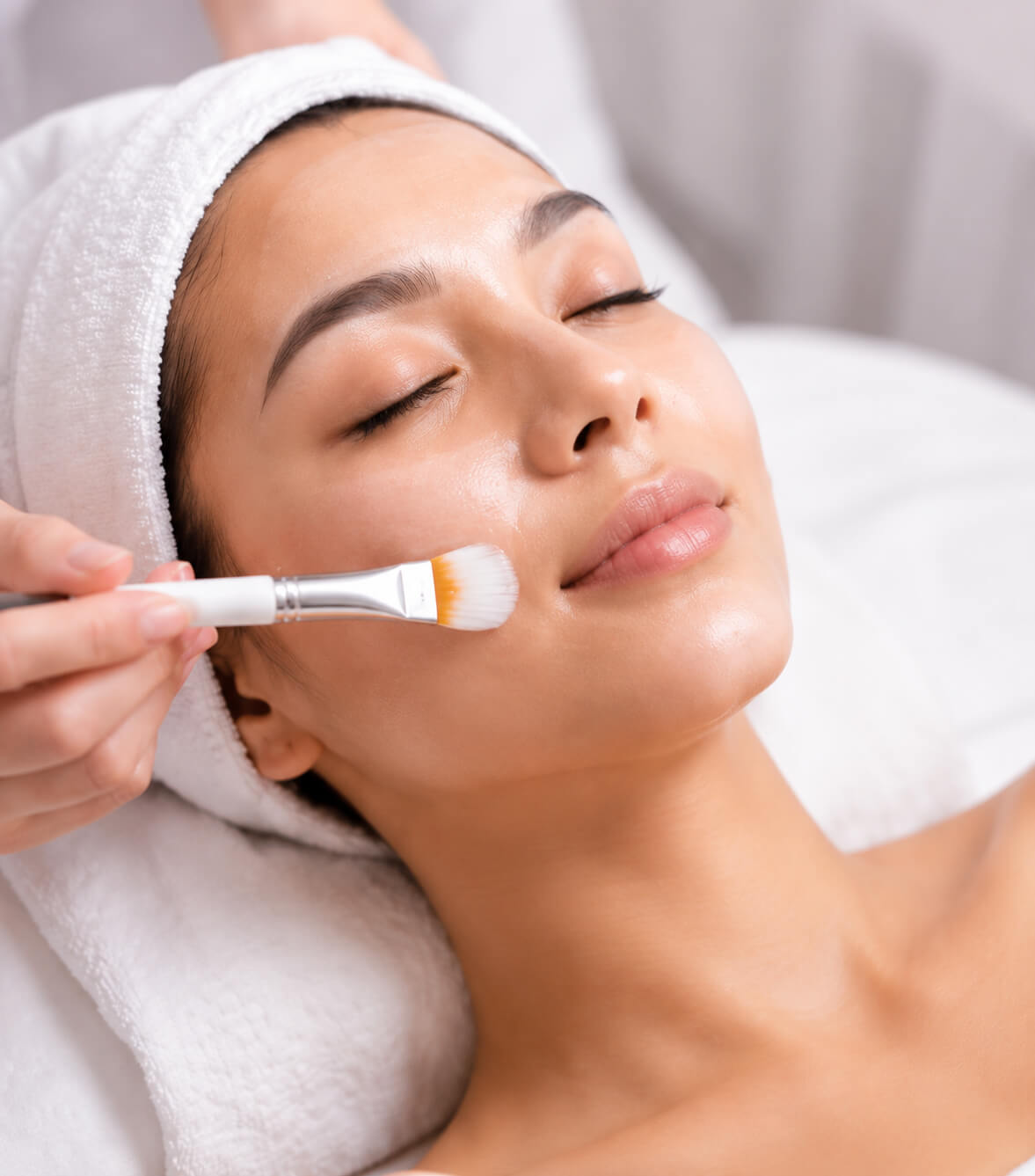 Woman receiving advanced facial treatment with brush